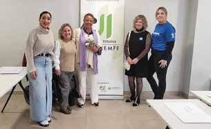 Profesionales de Málaga Inclusiva junto a la imagen de COCEMFE